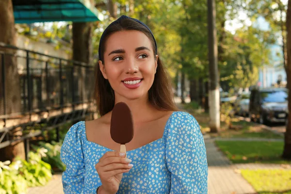 街の通りにチョコレートで釉アイスクリームを保持美しい若い女性 — ストック写真