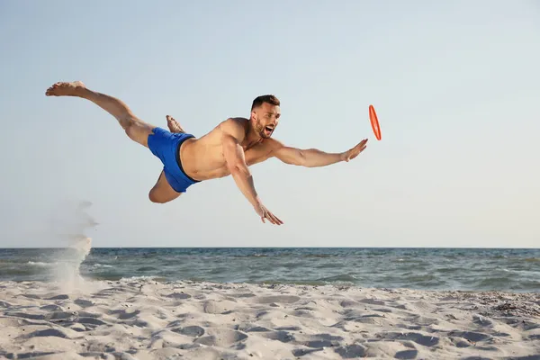 Pria Sportif Melompat Saat Mencoba Untuk Menangkap Disk Terbang Pantai — Stok Foto