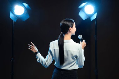 Motivasyon hoparlörü sahnede, arka planda mikrofon performansı