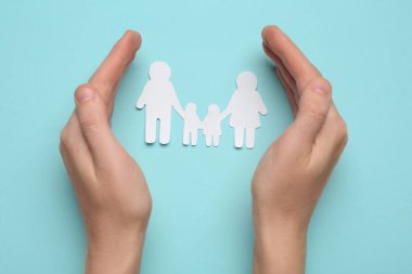 Turkuaz arka planda kağıt aile kesimi olan kadın, üst görünüm