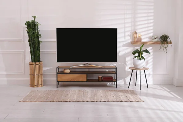 屋内の白い壁の近くに立つ現代的なテレビ インテリアデザイン — ストック写真