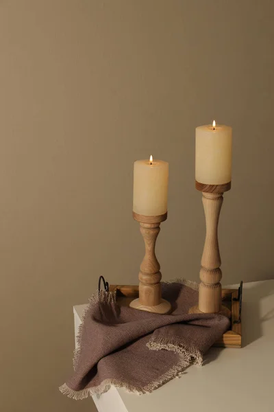 Halter Mit Brennenden Kerzen Auf Weißem Tisch Neben Brauner Wand — Stockfoto