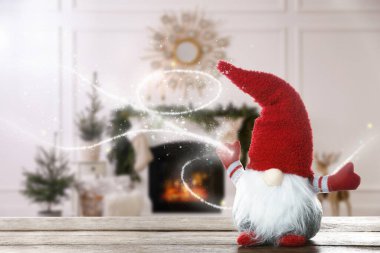 Odasındaki ahşap masada süslü süslemeleri olan komik noel cücesi. Metin için boşluk