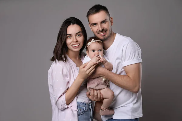 Família Feliz Casal Com Seu Bebê Bonito Fundo Cinza — Fotografia de Stock