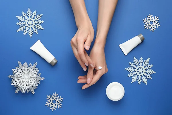 Mujer Aplicando Crema Mano Sobre Fondo Azul Vista Superior —  Fotos de Stock