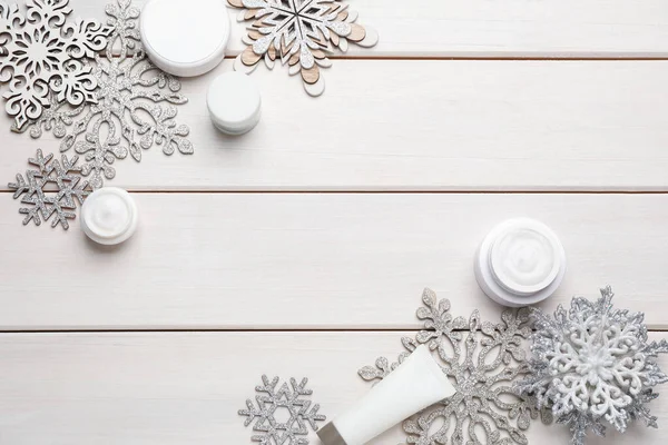 Flache Liegekomposition Mit Kosmetikprodukten Und Schneeflocken Auf Weißem Holztisch Platz — Stockfoto