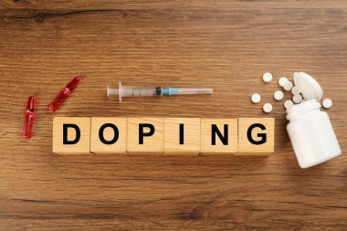 Kelime Doping ve uyuşturuculu küpleri tahta arka planda, düz yatıyordu