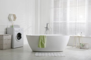 Banyoda küvetin yanında yerde şık bir paspas var. İç tasarım