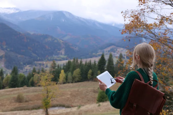 若い女性の山の中でタブレット上で バックビューを描画します テキストのスペース — ストック写真