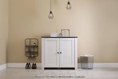 Aydınlık duvarın yanındaki çekmecelerin olduğu modern oda.