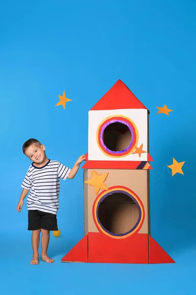 Roztomilý Malý Chlapec Hraje Kartonovou Raketou Světle Modrém Pozadí — Stock fotografie