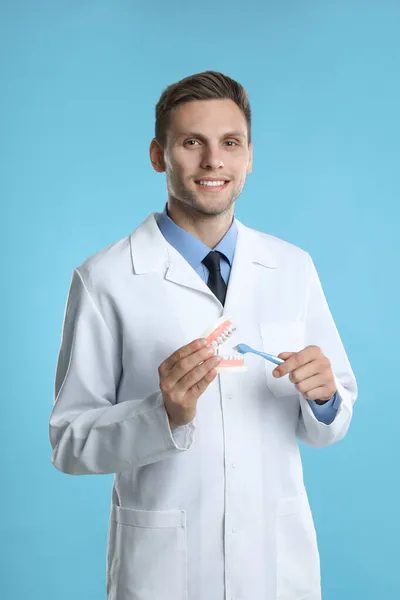 Dentista Com Modelo Mandíbulas Escova Dentes Fundo Azul Claro Demonstração — Fotografia de Stock