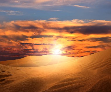 Gün batımında kumlu çöl manzarası