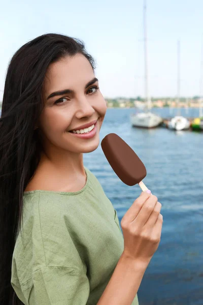 Hermosa Mujer Joven Sosteniendo Helado Esmaltado Chocolate Cerca Del Río — Foto de Stock