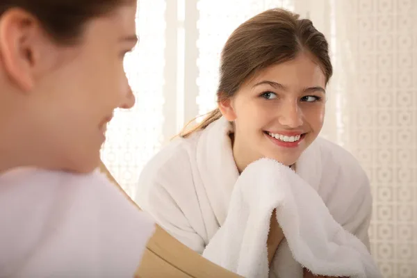 漂亮的少女在家里用毛巾在镜子前擦拭着脸 — 图库照片