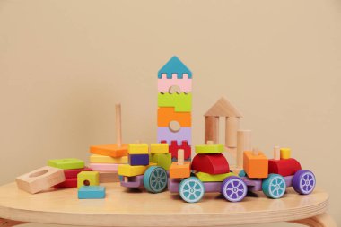 Masada bej arka planda farklı ahşap oyuncaklar var.