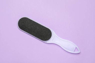 Mor arkaplandaki ayak dosyası, üst görünüm. Pedikür aracı