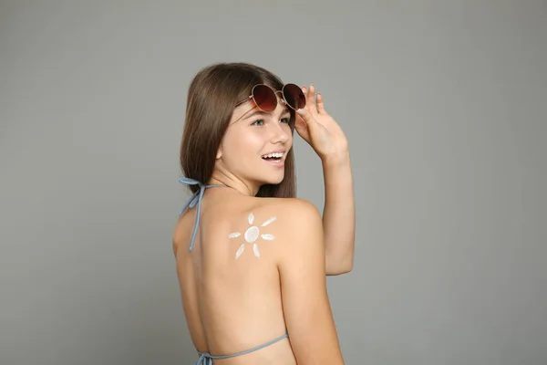 Tiener Meisje Met Zon Bescherming Crème Haar Rug Tegen Grijze — Stockfoto