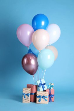 Açık mavi arka planda birçok hediye kutusu ve balon