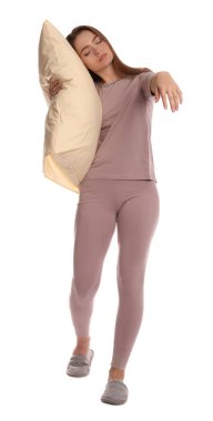 Beyaz arka planda uyurgezer haldeyken pijama ve terlik giyen genç bir kadın.
