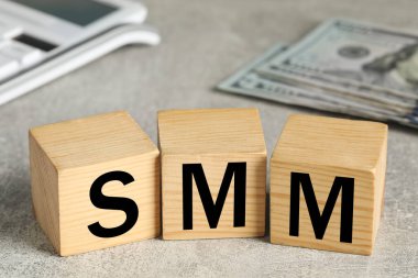 Gri taş masada SMM harfli tahta küpler.