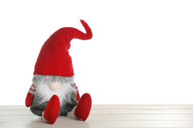 Beyaz arka plana karşı ahşap masadaki komik Noel cücesi. Metin için boşluk