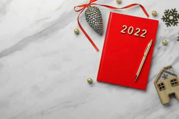 红色的计划者和圣诞装饰在白色大理石的背景上 平坦的地方有文字的空间 2022年新年目标 — 图库照片