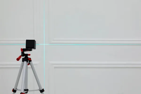 Příčná Úroveň Laseru Stativu Před Bílou Stěnou — Stock fotografie