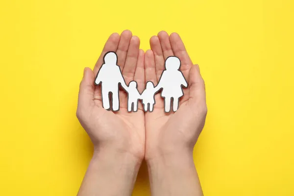 Woman Holding Paper Family Cutout Yellow Background Top View — Stock Photo, Image