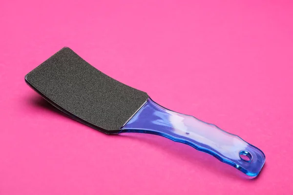 Blue foot file on pink background. Pedicure tool