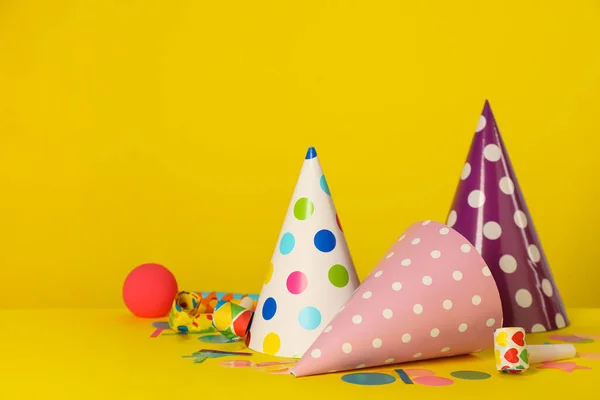 黄色の背景にカラフルなパーティー帽子やお祝いアイテム テキストのスペース — ストック写真