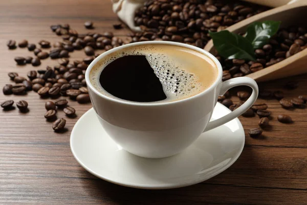 Tasse Aromatischer Heißer Kaffee Und Bohnen Auf Holztisch Nahaufnahme — Stockfoto