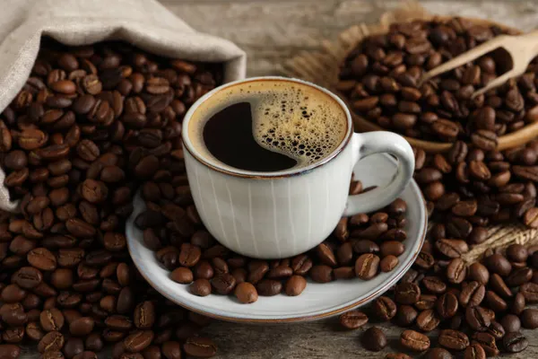 Tasse Aromatischer Heißer Kaffee Und Bohnen Auf Holztisch — Stockfoto