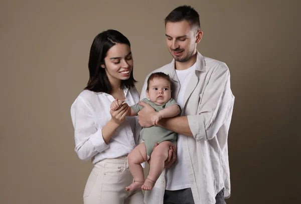 Família Feliz Casal Com Seu Bebê Bonito Fundo Bege — Fotografia de Stock
