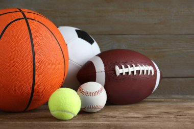 Tahta masada farklı spor topları var, yakın plan.