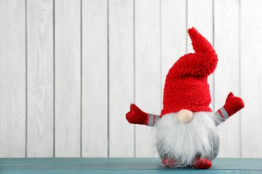 Turkuaz masada beyaz ahşap arka planda sevimli bir noel cücesi. Metin için boşluk