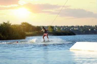 Genç çocuk nehirde wakeboard yapıyor. Aşırı su sporu