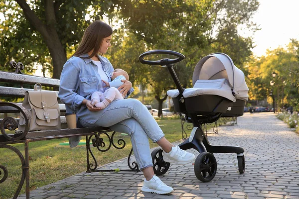 Parkta bebeğiyle oturan genç bir anne.
