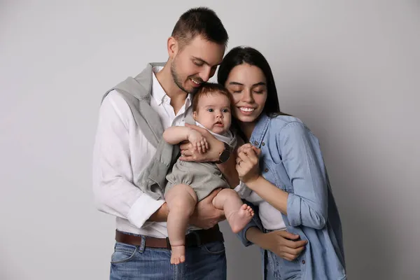 Família Feliz Casal Com Seu Bebê Bonito Fundo Cinza — Fotografia de Stock