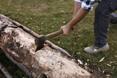 Baltalı bir adam dışarıda odun kesiyor, yakın plan.