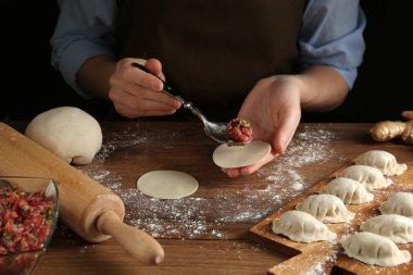 Ahşap masaya mangır ambalajını dolduran kadın, yakın plan.