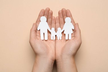 Bej arka planda kağıt aile resmi tutan kadın, üst görünüm