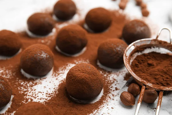 Вкусные Шоколадные Трюфели Какао Порошком Фундуком Белом Столе Крупным Планом — стоковое фото