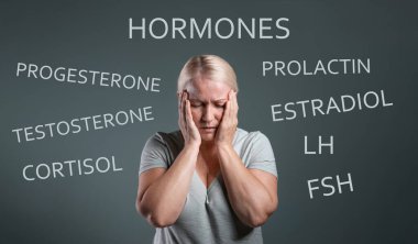Hormones imbalance. Upset mature woman and different words on grey background clipart