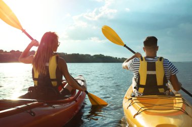 Nehirde kayak yapan can yelekli bir çift. Yaz etkinliği