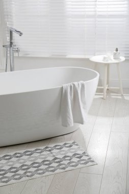 Banyoda küvetin yanında yerde şık bir paspas var. İç tasarım