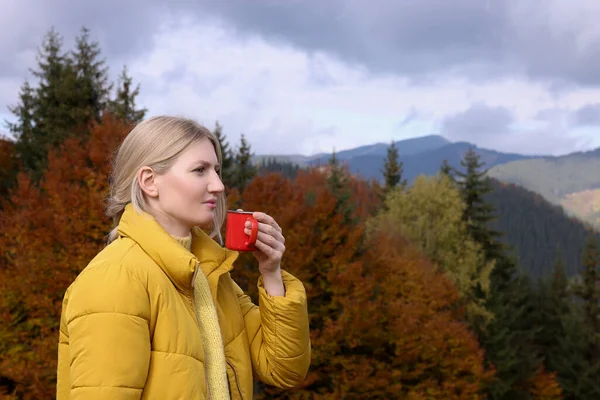 山の中で熱い飲み物のマグカップと若い女性 — ストック写真