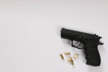 Beyaz arka planda tabanca ve mermiler, düz yatıyordu. Metin için boşluk
