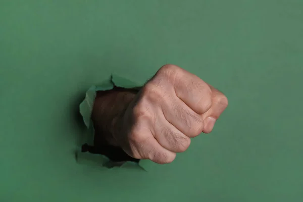 男は拳で緑の紙を突破 クローズアップ — ストック写真