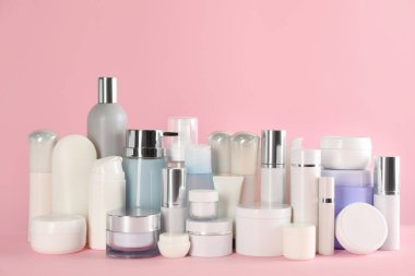 Pembe arka planda birçok farklı kozmetik ürünleri